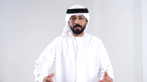 الصراخ بصوت مرتفع, بورترية لرجل عربي خليجي اماراتي يرتدي الكندورة و الغتره ينظر الى الكاميرا بايماءات الانفعال , مفهوم النقاش الحاد , خلفية بيضاء