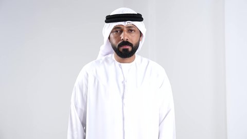 تنظيم ومراقبة الوقت، بورترية لرجل عربي خليجي اماراتي يرتدي الكندورة والغترة البيضاء يقوم بالنظر في الساعة ذكية ، تتبع الإشعارات عبر الساعات الحديثة, خلفية بيضاء