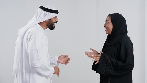 إيماءات السعادة والسرور, مفهوم الترابط الأسري, الحياة الزوجية الناجحة, أجواء عائلية مليئة بالحب, دردشة ومحادثات عائلية، بورتريه من الجانب لرجل عربي خليجي اماراتي يرتدي الكندورة و الغتره يقوم بالتحدث مع زوجته,  خفية بيضاء