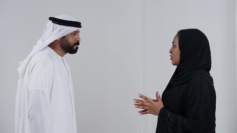 شجار بين الزوجين, بورترية لزوجان عربيان خليجيان امارتيان يرتديان الزي التقليدي يتجادلان مع بعضهم ، سوء تفاهم ، مشاكل عائلية ، صراع اسري ، ازمة في العلاقات الاسرية ، خلفية بيضاء