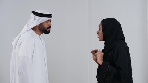 بورترية لزوجان عربيان خليجيان امارتيان يرتديان الزي التقليدي يتجادلان مع بعضهم ، شجار بين الزوجين ، سوء تفاهم ، مشاكل عائلية ، صراع اسري ، ازمة في العلاقات الاسرية ، خلفية بيضاء