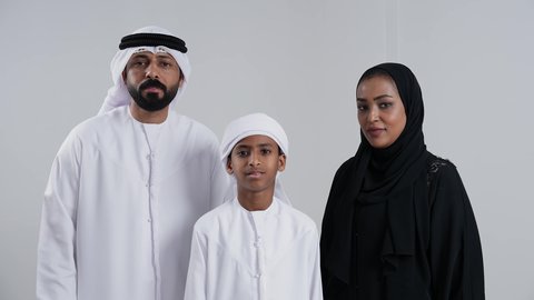 The feeling of satisfaction and acceptance, the concept of success and achieving goals, a close-up portrait of an Emirati Gulf Arab family wearing traditional attire looking at the camera with gestures of happiness and joy, raising their thumbs up with expressions of quality and excellence, white background.