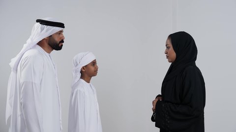 نقاش أسري بين الام والابن, بورتريه لام عربيه خليجيه اماراتية ترتدي العباءه و الحجاب تقوم بنصح ابنها برفقة والده، ولد عربية خليجي اماراتى يرتدي العمامة يقوم بالتحدث مع والدته  مفاهيم التربية الأسرية والعلاقات العائلية, خلفية بيضاء