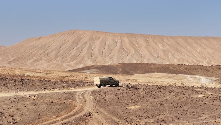 A daytime view of the mountains and volcanic craters in the Khaybar Lava Field, landmarks of Medina, natural volcanic fields, a destination for tourists and earth scientists, natural places in the Kingdom of Saudi Arabia.