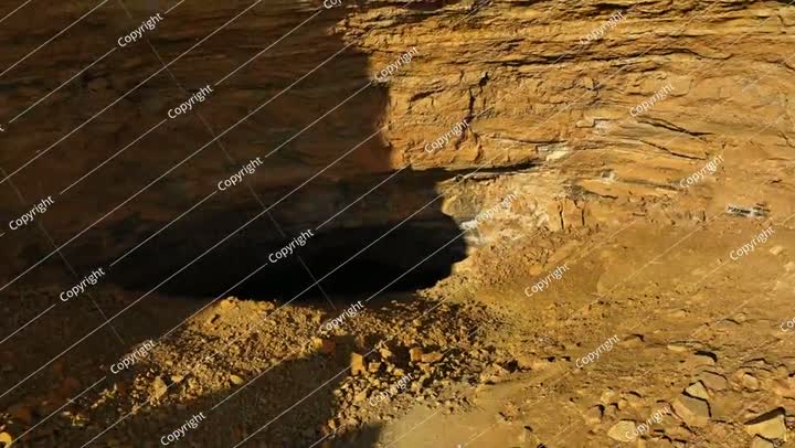 جوي: لقطة جوية من طائرة بدون طيار لكهف طبيعي شهير في منطقة صحراوية في يوم مشمس -