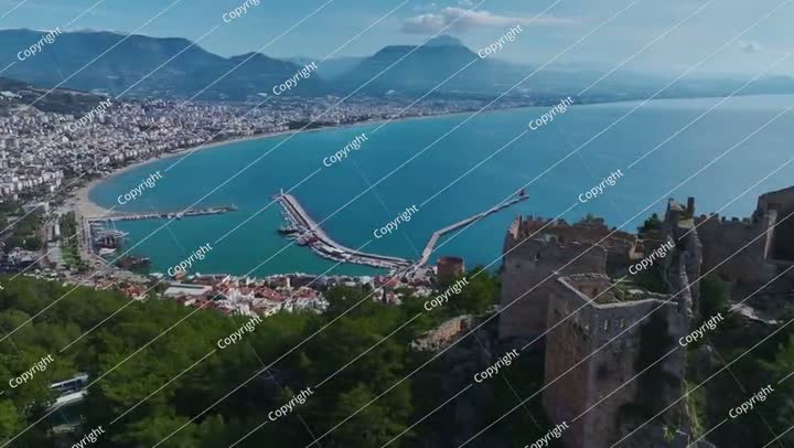 فيديو جوي لقلعة حجرية من العصور الوسطى ذات جدران شاهقة، محاطة بأشجار كثيفة