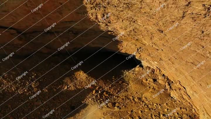 جويًا: كهف طبيعي شهير في منطقة صحراوية هادئة، وطائرة بدون طيار تحلق لأعلى