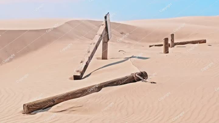 أعمدة وعوارض خشبية للوحات الإرشادية في قرية مهجورة مدفونة تحت رمال الصحراء