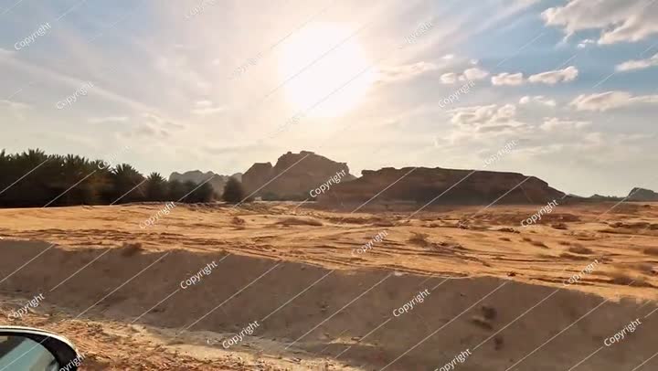 Driving on a main road - view from a car - in Al Ula, bright sun shines ove..