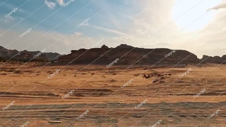Driving on a main road - view from a car - in Al Ula, bright sun shines ove..