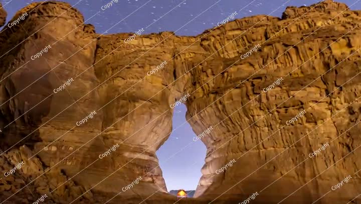 Time lapse of night stars, camping tent at bottle shape rock in Alula