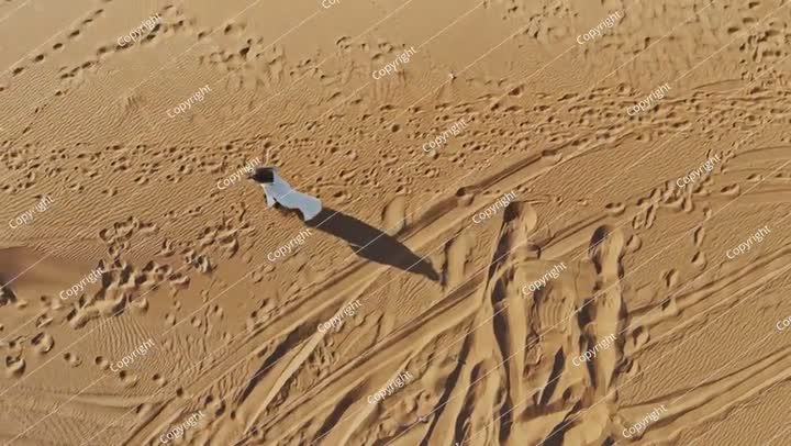 امرأة تمشي بمفردها في الصحراء السعودية، صورة جوية التقطتها طائرة بدون طيار