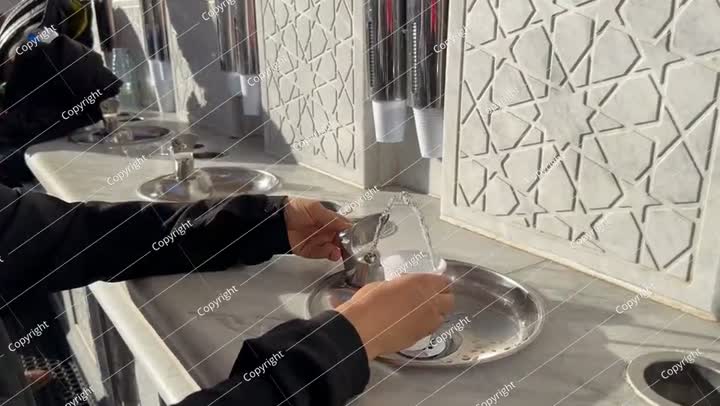 Pilgrim girl drinks zamzam water in the Prophet's Mosque in Medina Saudi Arabia.