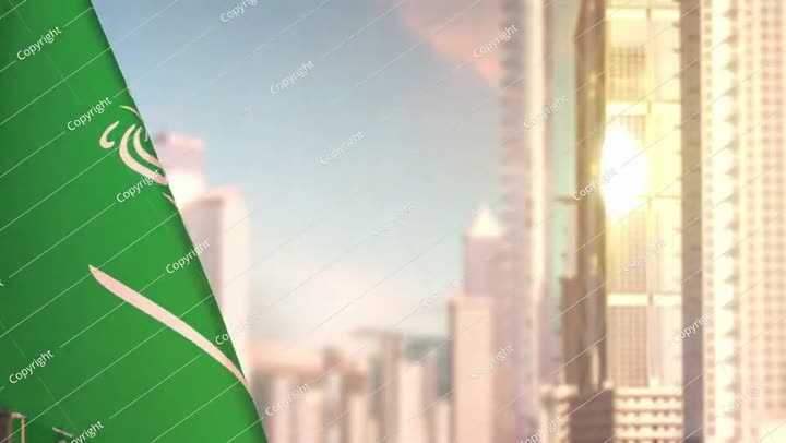 علم المملكة العربية السعودية عند غروب الشمس مع الهندسة المعمارية الحديثة للمدينة