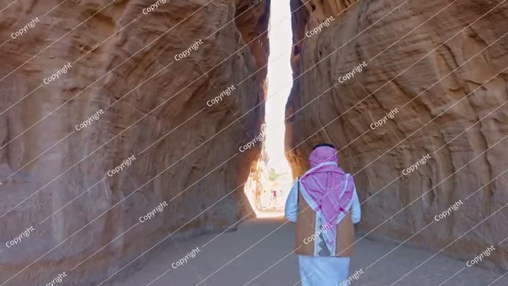 رجل عربي سعودي يمشي في ممر ضيق، الديوان، الحجر، المملكة العربية السعودية.