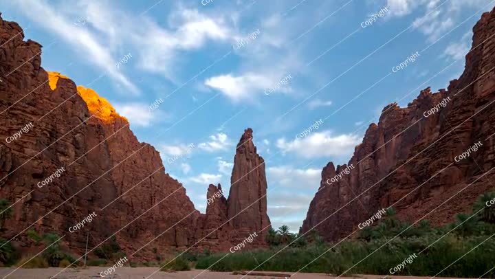 تصوير فوتوغرافي لغروب الشمس في الحجر الرملي وواحة النخيل في وادي الديسة، المملكة العربية السعودية