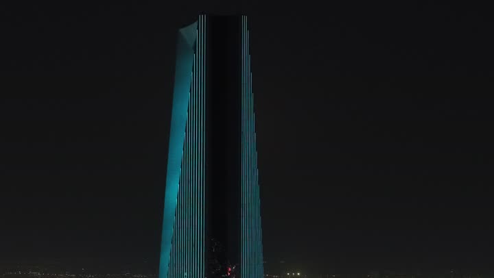 The development and urban progress of buildings in the Kingdom of Saudi Arabia, a close-up shot of the Kingdom Tower in the capital Riyadh at night, the architectural art of towers and skyscrapers, modern and advanced architectural designs.