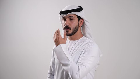معالجة حالات التهاب العصب البصري، العناية بالعين والحاجة لتعقيمها بشكل مستمر، اتباع تعليمات الطبيب واستخدام القطرة العينية، تصوير مقرب لرجل عربي خليجي إماراتي يرتدي الكندورة والغترة يقوم بوضع قطرة في عينه, أخذ العلاج اللازم للتخلص من احمرار العيون، خلفية بيضاء