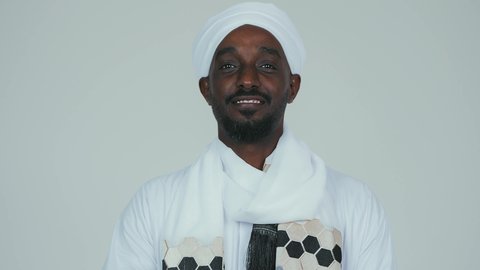 الاحتفال بالاستقلال ١ يناير، استذكار اليوم الوطني السوداني ١٩٥٦ م، الوقوف بثقة وايدي متقاطعة، ايماءات الاعتزاز والثقة،  حب الوطن والاعتزاز به، بورتريه مقرب لرجل عربي سوداني يرتدي التوب والشال والعمه البيضاء يقف بثقة واستقامة، خلفية بيضاء