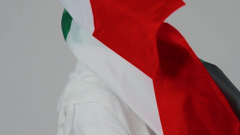 الوان علم الامارات المميزة، الاحتفال باليوم الوطني الإماراتي, الأعياد و المناسبات الوطنية, بورتريه مقرب لرجل عربي خليجي إماراتي يرتدي الكندورة والغترة البيضاء يقوم بوضع علم الإمارات العربية المتحدة على الاكتاف, إحياء ذكرى استقلال البلاد 1971 م، خلفية بيضاء