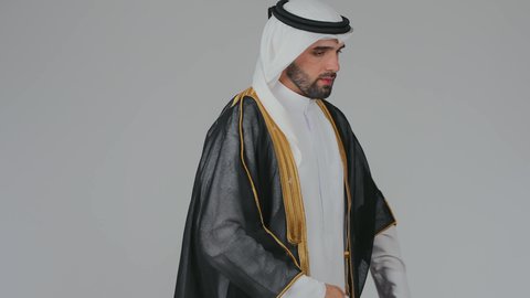 Celebrating Qatar National Day on December 18, national cultures and symbols, love for the homeland and belonging to it, commemorating the founding of the state, a portrait of a Qatari Gulf Arab man wearing traditional attire and a bisht, draping the Qatari flag over his shoulders with gestures of pride and honor, love for the homeland and belonging to it, white background.