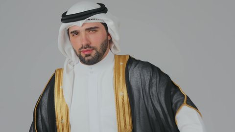 اليوم الوطني الاماراتي 1971 م، الاحتفال باليوم الوطني الإماراتي, الأعياد و المناسبات الوطنية, بورتريه مقرب لرجل عربي خليجي إماراتي يرتدي الكندورة والغترة والبشت البيضاء يقوم بوضع علم الإمارات العربية المتحدة على الاكتاف, خلفية بيضاء