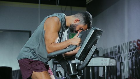 قضاء وقت ممتع على العجلة الهوائية، المحافظة على نظام الحياة الصحي، مفهوم الرشاقة واللياقة البدنية، انشطة ورياضات لتقوية العضلات و الاعصاب، رجل عربي خليجي سعودي يرتدي الملابس الرياضية يتمرن في النادي الرياضي