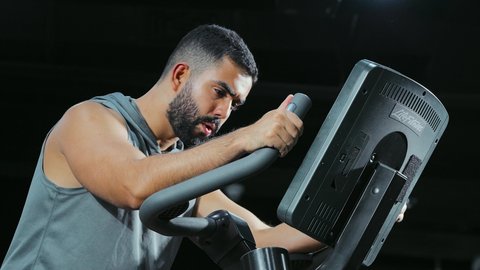 تنشيط الدورة الدموية, المحافظة على نظام الحياة الصحي، مفهوم الرشاقة والصحة، انشطة ورياضات لتقوية العضلات و الاعصاب، رجل عربي خليجي سعودي يرتدي الملابس الرياضية يتمرن على العجلة الهوائية