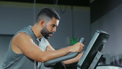 تحسين اللياقة العامة, قضاء وقت ممتع على العجلة الهوائية، المحافظة على نظام الحياة الصحي، انشطة ورياضات لتقوية العضلات و الاعصاب، رجل عربي خليجي سعودي يرتدي الملابس الرياضية يتمرن في النادي الرياضي