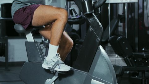 استخدام العجلة الهوائية، المحافظة على نظام الحياة الصحي، انشطة ورياضات لتقوية العضلات و الاعصاب، لقطة مقربة رجل عربي خليجي سعودي يرتدي الملابس الرياضية يتمرن في النادي الرياضي