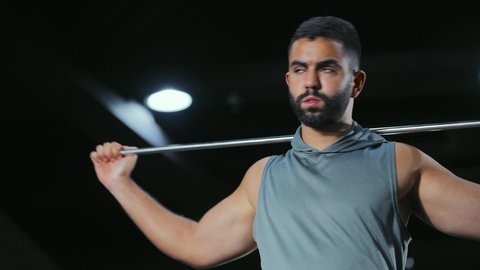 حركة تهيئ الجسم للراحة, نشاط شبابي يساعد على اللياقة البدنية, أهمية الرياضة لبناء جسد قوي، رجل عربي خليجي سعودي يرتدي الزي الرياضي يتمرن باستخدام العصا، أسلوب حياة صحي