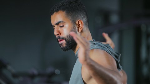 إطالة العضلات بعد التمرين, نشاط شبابي يساعد على اللياقة البدنية, أهمية الرياضة لبناء جسد قوي، رجل عربي خليجي سعودي يرتدي الزي الرياضي يتمرن باستخدام العصا، أسلوب حياة صحي، تعابير القوة والعزم