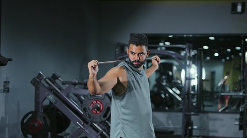 Increased flexibility and muscle stretching; a youthful activity that aids physical fitness; the importance of sports for building a strong body; a Saudi Arabian Gulf Arab man wearing sportswear exercises using a stick; a healthy lifestyle; expressions of strength and determination.