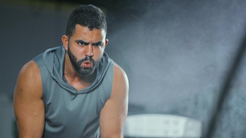 تمرين لتحسين الثبات, مفهوم الرشاقة واللياقة البدنية، انشطة ورياضات لتقوية العضلات و الاعصاب، لقطة مقربة لرجل عربي خليجي سعودي يرتدي الملابس الرياضية يقوم بممارسة التمارين بواسطة الحبل الثقيل, ايماءات القوة و العزم