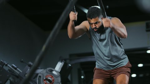 تنشيط عضلات الكتفين والذراعين, الدمج بين السرعة والسيطرة, المحافظة على توازن الجسم، مفهوم الرشاقة واللياقة البدنية، رجل عربي خليجي سعودي يرتدي الملابس الرياضية يقوم بممارسة التمارين بواسطة الحبل الثقيل