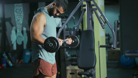 التركيز و الدقة في كل تكرار, التدرب على إتقان رفع الاوزان، اتباع نظام صحي، نشاط بدني للمحافظة على اللياقة الجسدية، شاب عربي خليجي سعودي يقوم بأداء التمارين باستخدام البار, رياضة كمال الأجسام، ايماءات القوة و الثقة