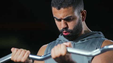 الاستمرارية في التدريب, التدرب على إتقان رفع الاوزان، اتباع نظام صحي، نشاط بدني للمحافظة على اللياقة الجسدية، شاب عربي خليجي سعودي يقوم بأداء التمارين باستخدام البار, رياضة كمال الأجسام، ايماءات القوة و الثقة