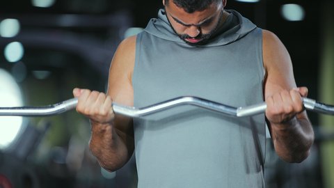 هواية رفع الأثقال الحديدية، اتباع نظام صحي، نشاط بدني للمحافظة على الصحة الجسدية، شاب عربي خليجي سعودي يقوم بالتمارين الرياضية باستخدام البار, رياضة كمال الأجسام، ايماءات القوة و الثقة
