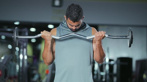 التدرب على إتقان رفع الاوزان، اتباع نظام صحي، نشاط بدني للمحافظة على اللياقة الجسدية، شاب عربي خليجي سعودي يقوم بالتمارين الرياضية باستخدام البار, رياضة كمال الأجسام، ايماءات القوة و الثقة، الاهتمام بالصحة و الرشاقة