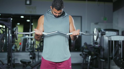القيام بالتمرينات الرياضية المقوية, التدرب على إتقان رفع الاوزان، اتباع نظام صحي، نشاط بدني للمحافظة على اللياقة الجسدية، شاب عربي خليجي سعودي يقوم بأداء التمارين باستخدام البار, رياضة كمال الأجسام، ايماءات القوة و الثقة