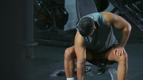 بناء عضلات الجسم وتقويتها, رياضة كمال الأجسام، استخدام الاثقال الرياضية، شاب عربي خليجي سعودي يرتدي الزي الرياضي يقوم بممارسة تمارين رفع الأوزان، أسلوب حياة صحي، نشاط شبابي يساعد على اللياقة البدنية, الدمج بين القوة و الثبات