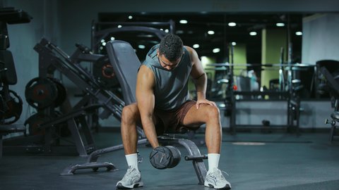 رياضة كمال الأجسام، استخدام الاثقال الرياضية، شاب عربي خليجي سعودي يرتدي الزي الرياضي يقوم بممارسة تمارين رفع الأوزان،  تقوية الأعصاب والعضلات، أسلوب حياة صحي، نشاط شبابي يساعد على اللياقة البدنية