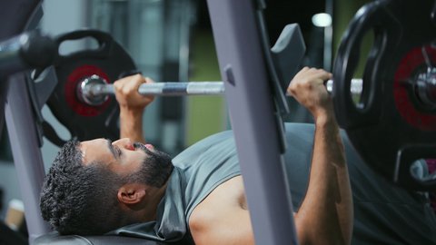 المحافظة على التوازن الجسدي، اتباع أسلوب حياة صحي، تقوية الأعصاب والعضلات، ايماءات القوة والنشاط، مفهوم اللياقة والرشاقة، استخدام الاثقال الرياضية، شاب عربي خليجي سعودي يرتدي الزي الرياضي يقوم بممارسة تمارين رفع الأوزان