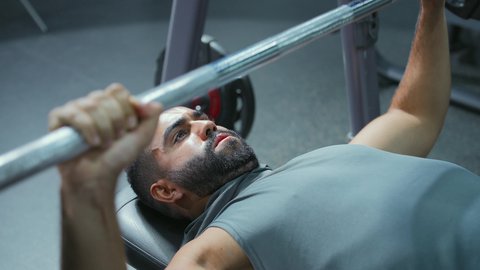 إيماءات القوة والثقة، الاهتمام بالصحة واللياقة الجسدية، رياضة كمال الأجسام، استخدام الاثقال الرياضية،  شاب عربي خليجي سعودي يرتدي الزي الرياضي يقوم بممارسة تمارين رفع الأوزان، تقوية الأعصاب والعضلات، أسلوب حياة صحي