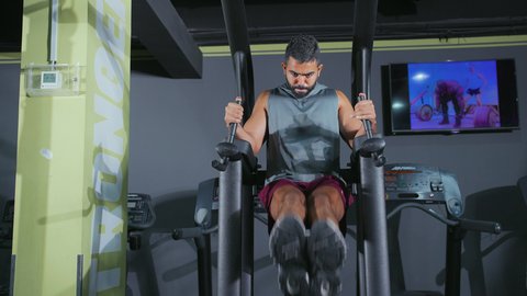 الاهتمام بالصحة و الرشاقة, استخدام الأجهزة الرياضية، شاب عربي خليجي سعودي يرتدي الزي الرياضي يقوم بممارسة تمرين تقوية عضلات الصدر و الذراعين و الكتفين على جهاز المتوازي, تقوية الأعصاب والعضلات، أسلوب حياة صحي، نشاط شبابي يساعد على اللياقة البدنية