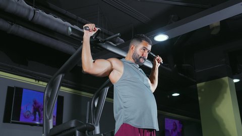 بناء الكتلة العضلية، استخدام الأجهزة الرياضية، شاب عربي خليجي سعودي يرتدي الزي الرياضي يقوم بممارسة تمرين تقوية عضلات الصدر و الذراعين و الكتفين على جهاز المتوازي, تقوية الأعصاب والعضلات، أسلوب حياة صحي، نشاط شبابي يساعد على اللياقة البدنية