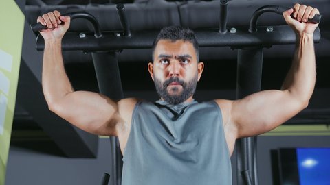 التركيز على تقوية العضلات العلوية, الدمج بين القوة و الثبات, استخدام الأجهزة الرياضية، شاب عربي خليجي سعودي يرتدي الزي الرياضي يقوم بممارسة تمرين تقوية الصدر و الذراعين و الكتفين على جهاز المتوازي, أسلوب حياة صحي، نشاط شبابي يساعد على اللياقة البدنية