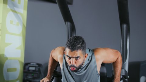 أهمية الرياضة لبناء جسد قوي، استخدام الأجهزة الرياضية، شاب عربي خليجي سعودي يرتدي الزي الرياضي يقوم بممارسة تمرين تقوية عضلات الصدر و الذراعين و الكتفين على جهاز المتوازي, تقوية الأعصاب والعضلات، أسلوب حياة صحي