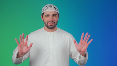 مفهوم السلام والترحيب, تعابير الوجه ولغة الجسد المختلفة, بورتريه لرجل عربي اماراتي خليجي يرتدي الكندورة والطاقية يرفع يديه لإلقاء التحية, ايماءات تدل على السعادة, خلفية ملونة