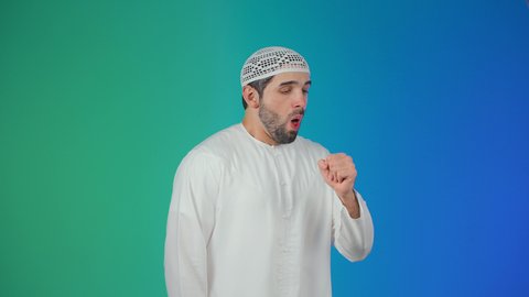 الإصابة بالأنفلونزا ونزلات البرد, إيماءات الإرهاق والتعب الشديد، الكحة والتهاب الحلق والحاجة للعلاج، بورتريه لرجل عربي خليجي اماراتي يرتدي الكندورة والطاقية يضع يده أمام فمه ويقوم بالسعال, خلفية ملونه